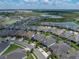 Sprawling aerial shot of neighborhood near a tranquil lake with lush greenery, offering a serene residential atmosphere at 31510 Cabana Rye Ave, San Antonio, FL 33576