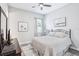 Cozy bedroom features neutral tones, wood-look floors, a ceiling fan, and a queen bed with patterned bedding at 31510 Cabana Rye Ave, San Antonio, FL 33576