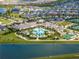 Aerial view of the community amenities including a resort-style pool, tennis courts, and clubhouse by a lake at 31510 Cabana Rye Ave, San Antonio, FL 33576