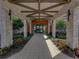 Elegant entrance with stone pillars, wood accents, and glass doors surrounded by lush greenery at 31510 Cabana Rye Ave, San Antonio, FL 33576
