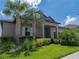 Charming exterior view featuring lush landscaping, mature palm trees, and a well-maintained lawn enhancing the home's curb appeal at 31510 Cabana Rye Ave, San Antonio, FL 33576