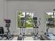 Bright gym area with state-of-the-art elliptical machines overlooking the pool and lush scenery at 31510 Cabana Rye Ave, San Antonio, FL 33576