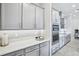 Modern kitchen features white cabinets, mosaic backsplash, quartz countertops, and stainless steel appliances at 31510 Cabana Rye Ave, San Antonio, FL 33576