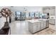 Open-concept living room flows to kitchen; boasts tile floors, stainless appliances, island, and ample natural light at 31510 Cabana Rye Ave, San Antonio, FL 33576