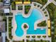 Overhead shot of a lagoon style pool with palm islands, sun loungers, and surrounding community buildings at 31510 Cabana Rye Ave, San Antonio, FL 33576
