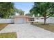 Inviting single-Gathering home with a paved driveway, showcasing its well-maintained lawn and charming facade at 3303 W Ballast Point Blvd, Tampa, FL 33611