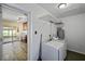 This laundry room offers a washer and dryer, and an open doorway to the kitchen at 3303 W Ballast Point Blvd, Tampa, FL 33611