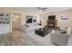 This spacious living room boasts a brick fireplace, ceiling fan, and wood-look flooring at 3303 W Ballast Point Blvd, Tampa, FL 33611