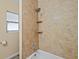 This is the shower with the bathtub, shower head, and shelves for storage at 3303 W Ballast Point Blvd, Tampa, FL 33611
