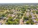 Expansive aerial view of a neighborhood with lush greenery and a glimpse of the distant ocean at 331 Archimedes St, Dunedin, FL 34698