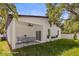 Inviting outdoor patio with a ceiling fan, dining set, and lush green lawn at 331 Archimedes St, Dunedin, FL 34698