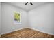Bright bedroom featuring wood floors, white trim, and a window at 331 Archimedes St, Dunedin, FL 34698