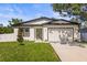 Charming single-story home featuring a manicured lawn, and an attached garage at 331 Archimedes St, Dunedin, FL 34698