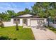 Charming single-story home featuring a manicured lawn, and an attached garage at 331 Archimedes St, Dunedin, FL 34698