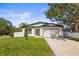 Charming single-story home with a well-manicured lawn, attached garage, and classic white exterior at 331 Archimedes St, Dunedin, FL 34698