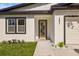 Close up of a bright home's front entry with modern door and landscape at 331 Archimedes St, Dunedin, FL 34698
