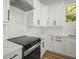 Kitchen with white cabinets, stainless steel appliances, granite counters, and wood-look flooring at 331 Archimedes St, Dunedin, FL 34698