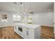 Bright kitchen featuring a large island, modern pendant lighting, and wood-look flooring at 331 Archimedes St, Dunedin, FL 34698