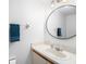 Clean and simple bathroom with white vanity, round mirror, and modern fixtures at 3343 Fox Hunt Dr, Palm Harbor, FL 34683