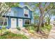 Attractive two-story blue townhouse featuring a landscaped front yard and a welcoming entrance at 3343 Fox Hunt Dr, Palm Harbor, FL 34683