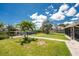 Spacious backyard with a lush lawn, mature trees, a boat dock, and a screened lanai providing a serene outdoor space at 3420 Santa Clara Dr, Punta Gorda, FL 33983