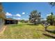 Large backyard featuring lush green lawn, mature palm trees, and a screened-in lanai, perfect for outdoor living at 3420 Santa Clara Dr, Punta Gorda, FL 33983