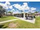 Backyard featuring a screened-in lanai, concrete patio with grill, and well-maintained lawn offering comfortable outdoor living at 3420 Santa Clara Dr, Punta Gorda, FL 33983