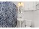 Small bathroom features a pedestal sink, toilet, cabinet, and shower with a blue patterned curtain at 3420 Santa Clara Dr, Punta Gorda, FL 33983