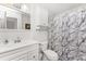 Well-lit bathroom with a white sink, toilet, and a shower with patterned curtain at 3420 Santa Clara Dr, Punta Gorda, FL 33983