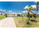 Charming single-story home with a well-manicured lawn, mature landscaping, and a concrete driveway leading to a one-car garage at 3420 Santa Clara Dr, Punta Gorda, FL 33983