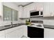 Well-lit kitchen features white cabinetry, stainless steel appliances, and granite countertops at 3420 Santa Clara Dr, Punta Gorda, FL 33983