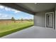 Covered back patio overlooking a grassy field and tranquil landscape at 35280 Big Hawk Ln, Zephyrhills, FL 33541