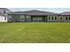 Expansive backyard showing the rear exterior with multiple windows and sliding glass doors at 35280 Big Hawk Ln, Zephyrhills, FL 33541