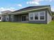 Expansive backyard with manicured lawn and view of covered patio and windows at 35280 Big Hawk Ln, Zephyrhills, FL 33541