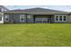 Large, flat backyard with lush grass, sliding glass doors and an exterior view of the home's rear at 35280 Big Hawk Ln, Zephyrhills, FL 33541