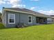 Lush backyard with expansive lawn and exterior home view, including AC unit at 35280 Big Hawk Ln, Zephyrhills, FL 33541