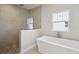 Modern bathroom featuring a glass-enclosed shower, soaking tub, and pebble stone flooring at 35280 Big Hawk Ln, Zephyrhills, FL 33541