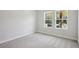 A bright bedroom featuring two windows and plush carpeting throughout at 35280 Big Hawk Ln, Zephyrhills, FL 33541