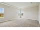 A spacious carpeted bedroom featuring a tray ceiling and bright natural light from large windows at 35280 Big Hawk Ln, Zephyrhills, FL 33541