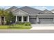 Charming gray home featuring a well-maintained lawn, neutral trim, and an attached two-car garage at 35280 Big Hawk Ln, Zephyrhills, FL 33541