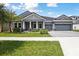 Beautiful home with a well-manicured lawn, lush landscaping, and a welcoming three-car garage at 35280 Big Hawk Ln, Zephyrhills, FL 33541