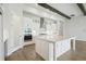 Modern kitchen featuring an island, stainless steel appliances, white cabinetry, and wood-look flooring at 35280 Big Hawk Ln, Zephyrhills, FL 33541
