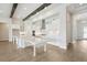 Bright kitchen with white cabinetry, stainless steel appliances, large island, and decorative wood beams at 35280 Big Hawk Ln, Zephyrhills, FL 33541