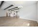 Expansive living room area with modern lighting, wood flooring, and adjacent white kitchen at 35280 Big Hawk Ln, Zephyrhills, FL 33541