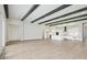Spacious living room with hardwood flooring, modern lighting, and decorative ceiling beams at 35280 Big Hawk Ln, Zephyrhills, FL 33541