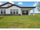 A spacious backyard featuring lush green grass and a covered patio area for outdoor relaxation at 35571 Stableton Ln, Zephyrhills, FL 33541