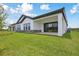 Exterior of home features a large backyard and covered patio at 35571 Stableton Ln, Zephyrhills, FL 33541