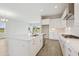 Well-lit open kitchen boasts a large island, white cabinetry, and stainless steel appliances at 35571 Stableton Ln, Zephyrhills, FL 33541