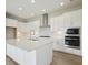 Bright and airy kitchen featuring white cabinets, stainless steel appliances, and a large island at 35571 Stableton Ln, Zephyrhills, FL 33541