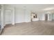 Spacious living room with light colored wood flooring, an open floor plan, and natural light at 35571 Stableton Ln, Zephyrhills, FL 33541